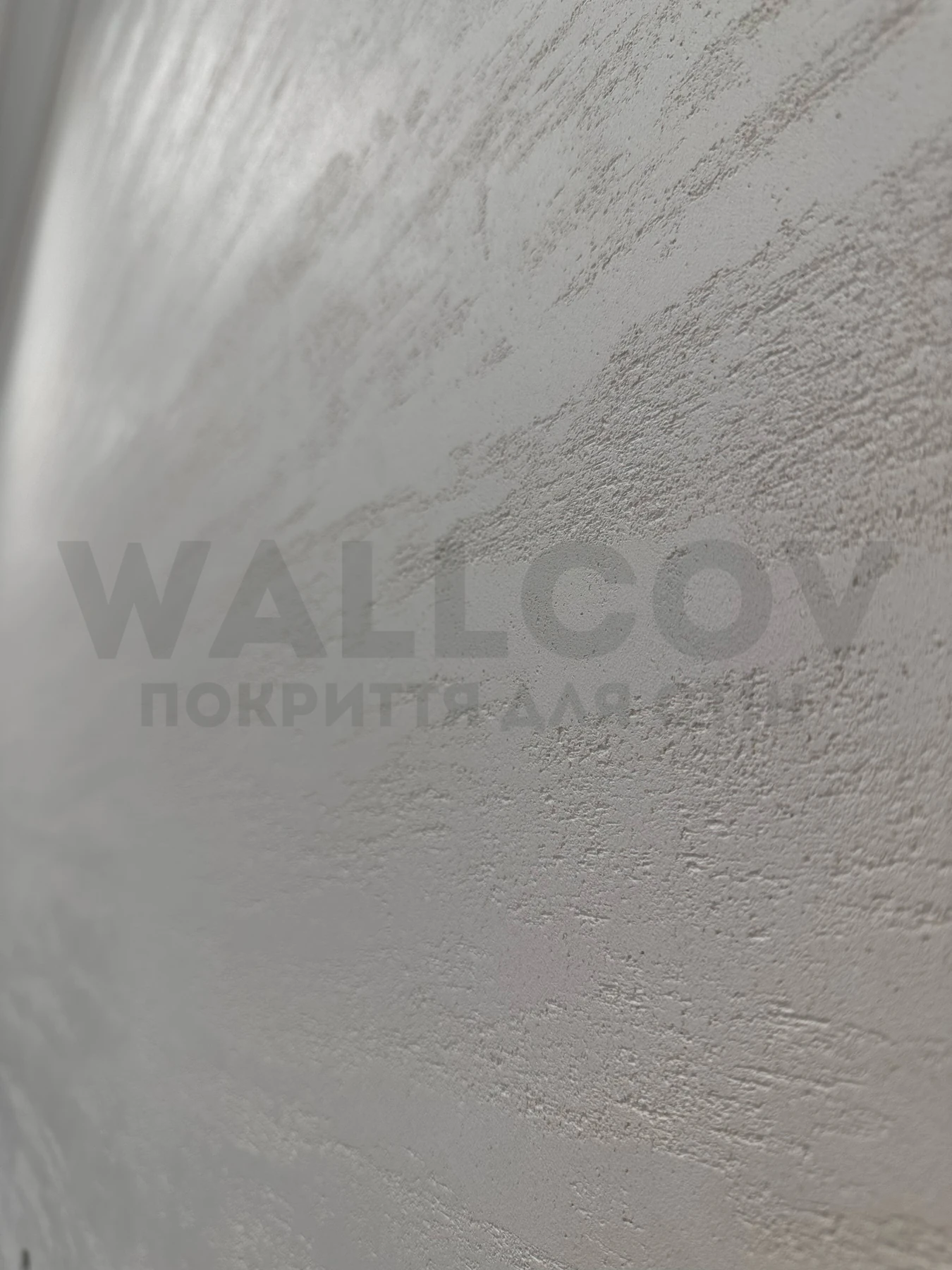 Реальний об'єкт Wallcov: матовий травертин при бічному денному світлі, крупно